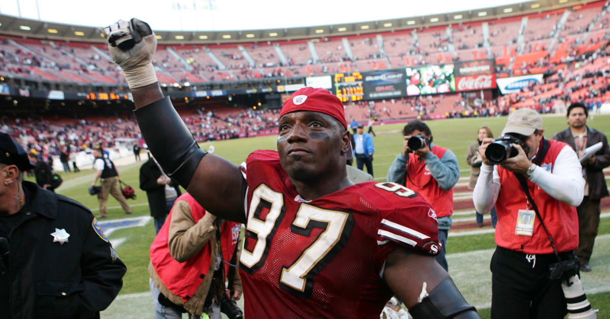 Former NFL player Bryant Young, right, poses with his bust and