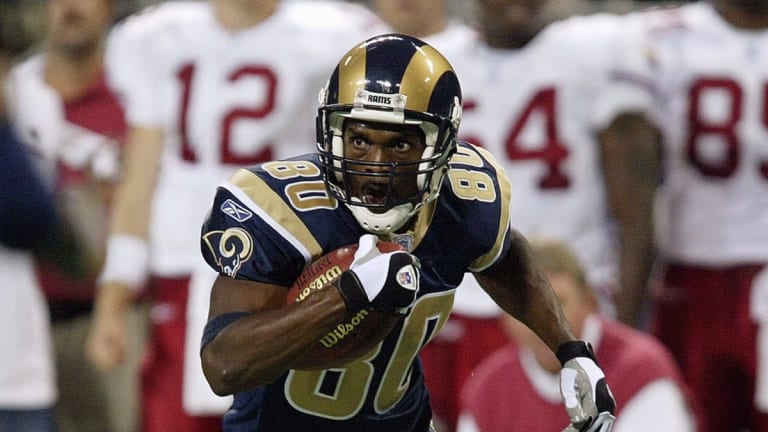 St. Louis Rams wide receiver Isaac Bruce holds one of his jerseys